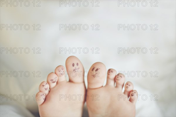 Toes of Caucasian girl with smiley face drawings
