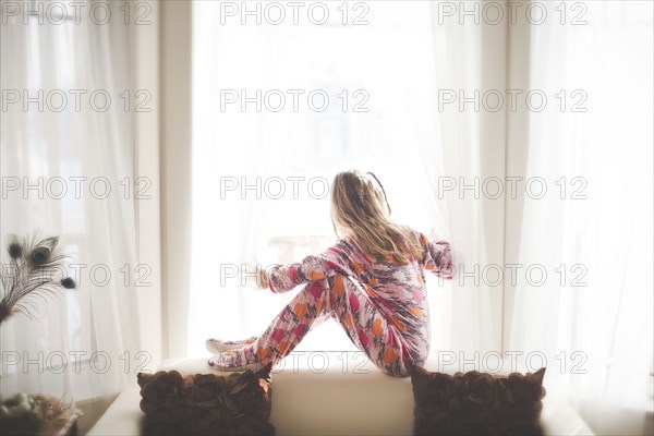 Caucasian girl sitting in window
