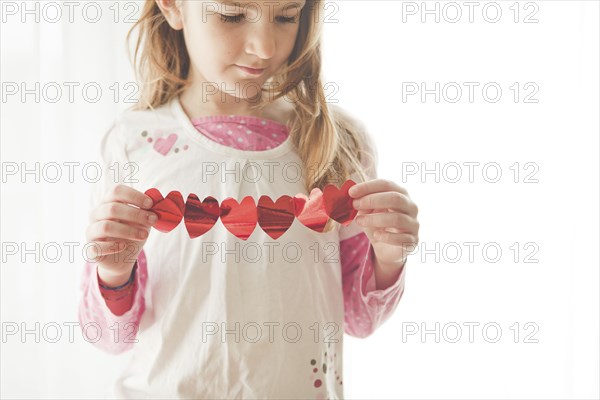 Caucasian girl holding heart-shaped bunting