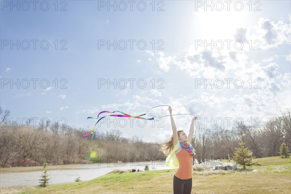 Caucasian girl playing with ribbons in park