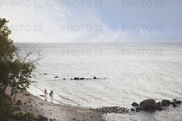 Caucasian girls standing on remote beach