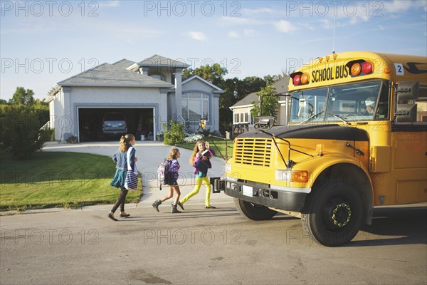 Caucasian girls walking to school bus