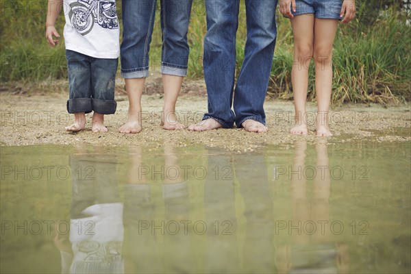 Family wearing jeans at still puddle