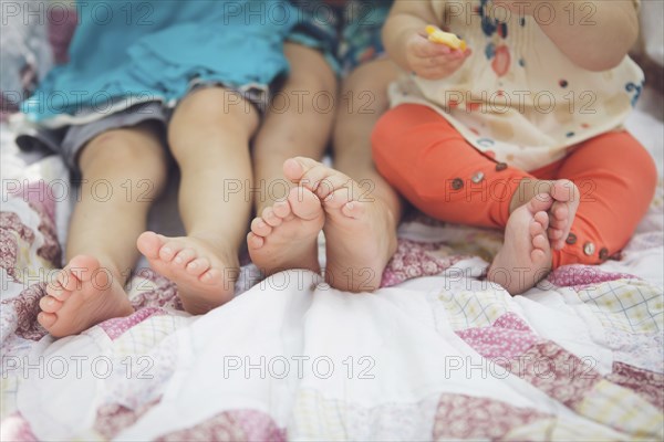 Close up of feet of siblings on blanket