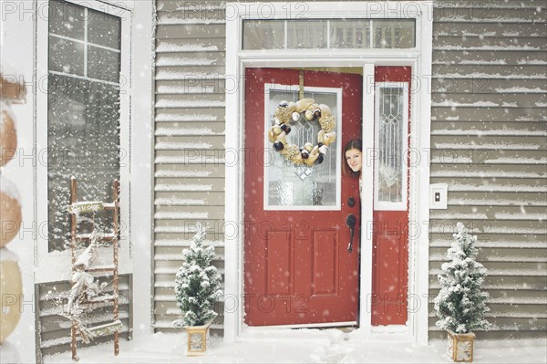 Caucasian woman opening door to snow