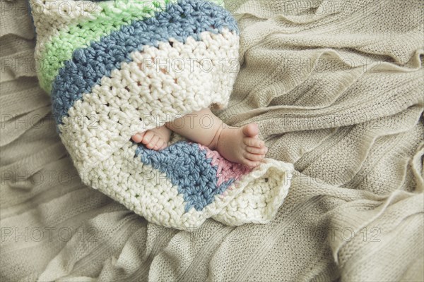 Close up of feet of newborn baby wrapped in blanket