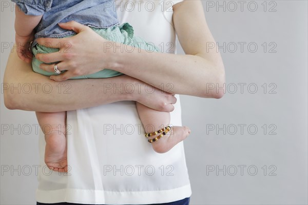 Midsection view of mother holding baby