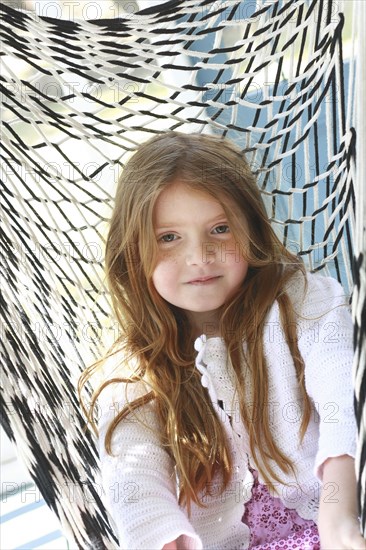 Caucasian girl sitting in hammock