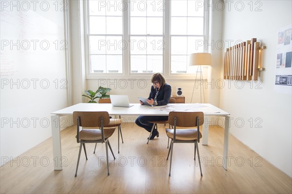 Businesswoman using digital tablet at desk in office