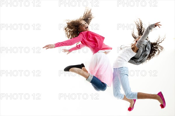 Mixed race girls jumping for joy