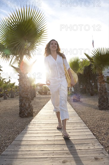 Woman walking on wooden boardwalk in park