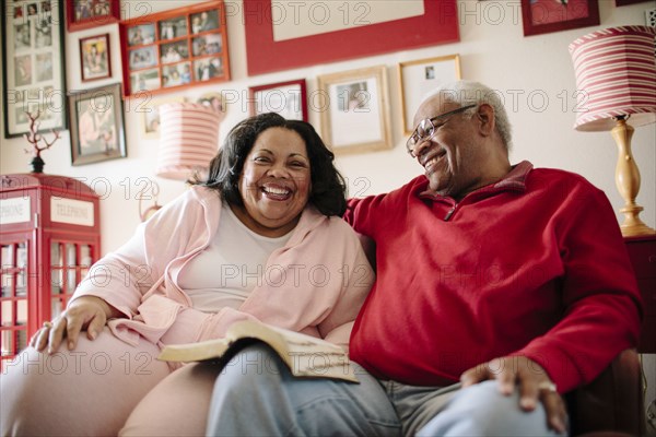 Couple reading book in living room