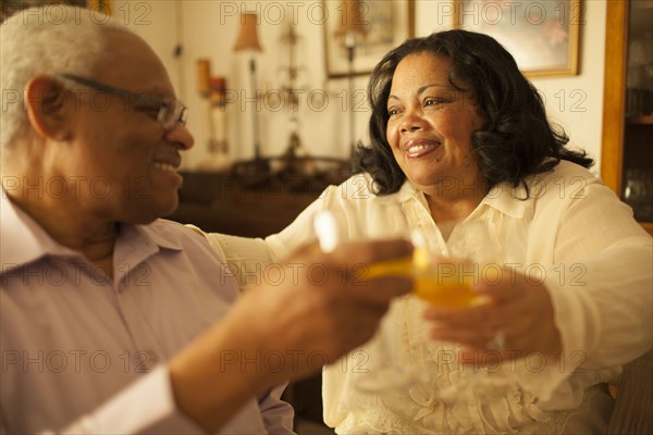 Couple toasting each other with wine in living room