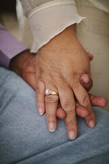 Close up of husband and wife holding hands