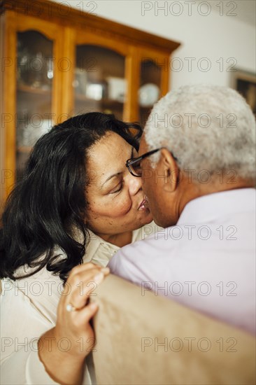 Close up of kissing couple in dining room