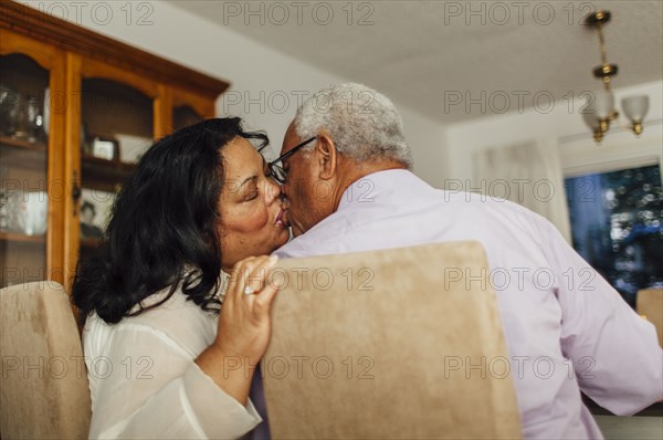 Close up of kissing couple in dining room