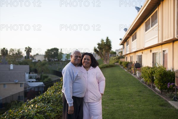 Couple smiling in backyard of apartment building