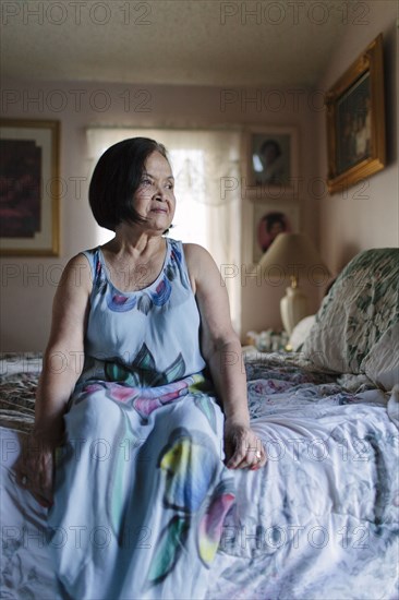 Smiling older woman sitting on bed