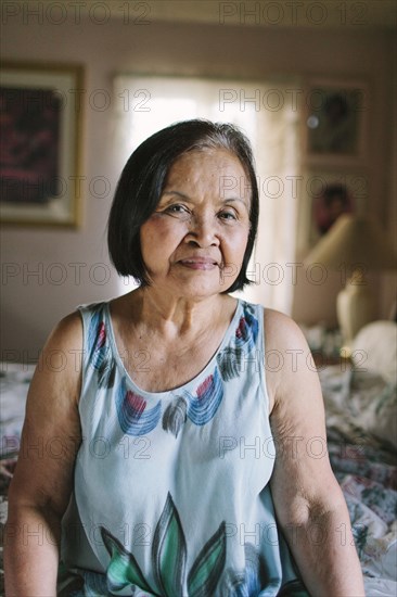 Smiling older woman sitting on bed