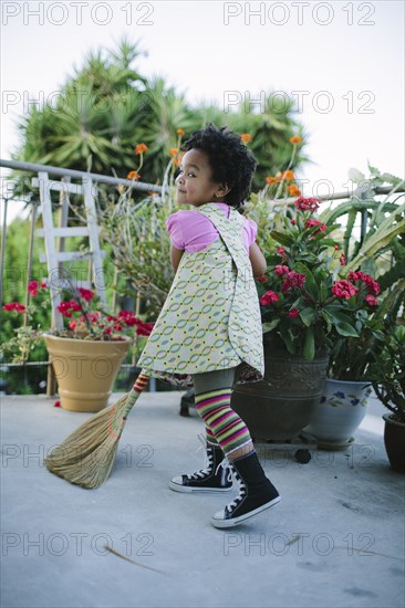 Girl sweeping patio with broom