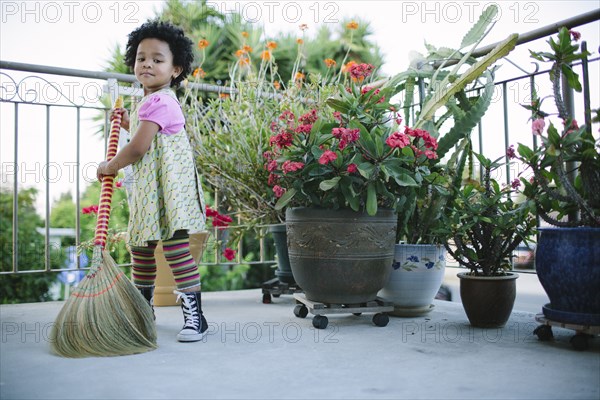 Girl sweeping patio with broom