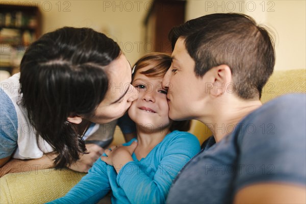 Caucasian mothers kissing daughter in living room