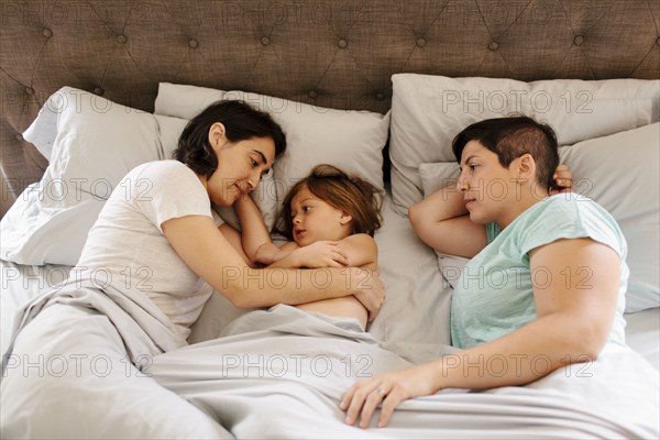 Caucasian family laying in bed