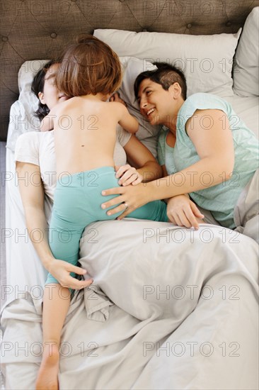 Caucasian family playing in bed