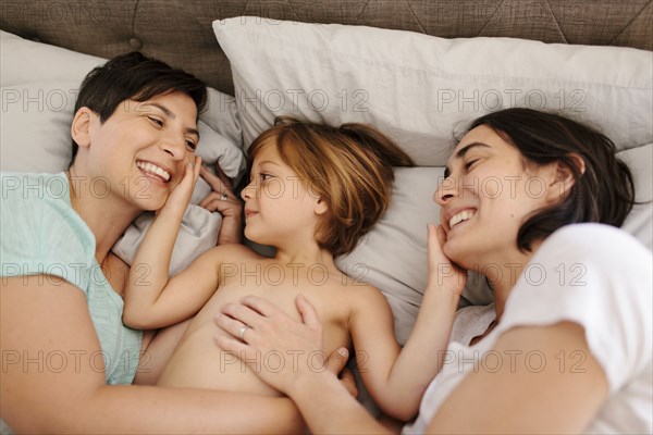 Caucasian family playing in bed