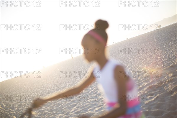 Defocused view of girl riding bicycle on beach
