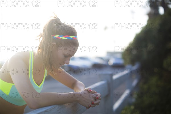 Close up of woman leaning over fence in parking lot