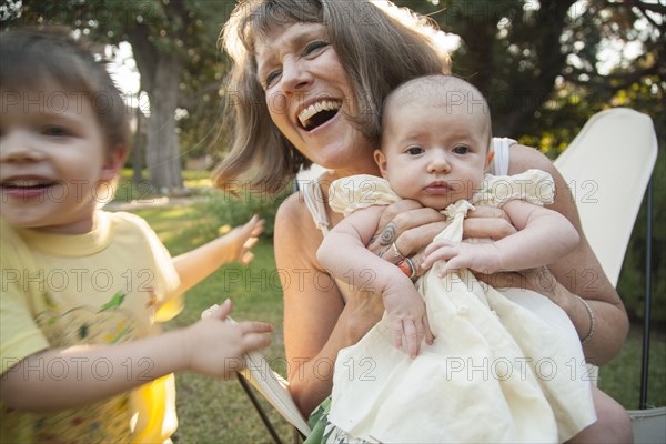 Grandmother playing with grandchildren in backyard