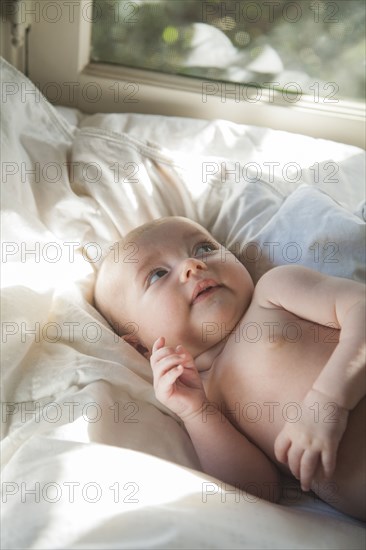 Caucasian baby laying on bed