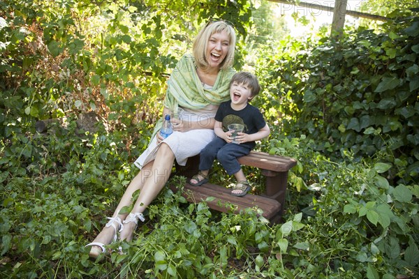 Caucasian grandmother and grandson sitting in garden