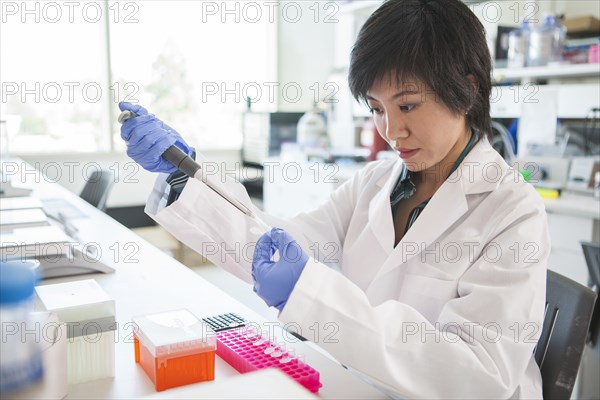 Scientist pipetting liquid into test tube in laboratory