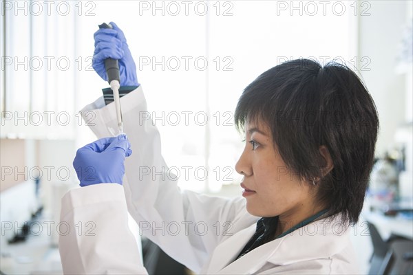 Scientist pipetting liquid into test tube in laboratory