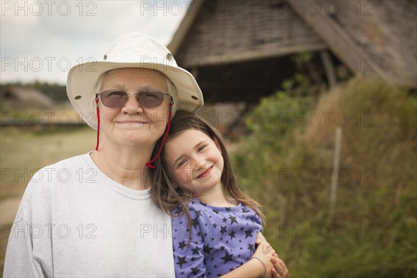 Caucasian grandmother hugging granddaughter in backyard