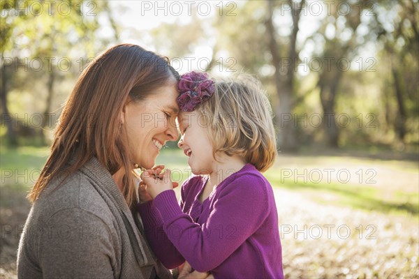 Mother and daughter hugging in park