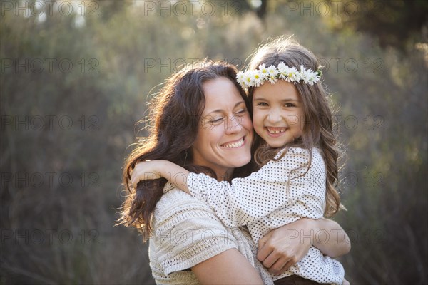 Mother and daughter hugging in park