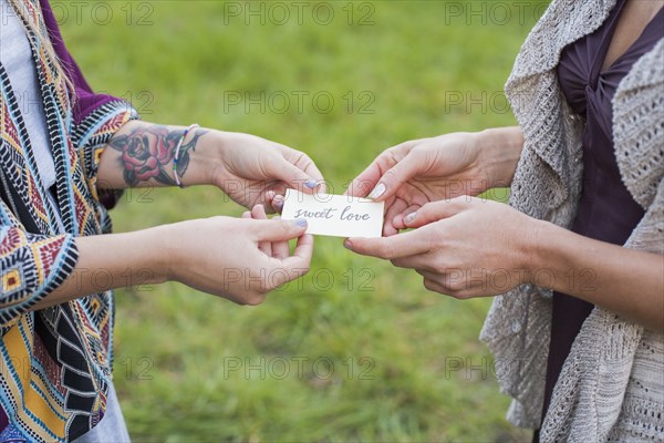 Close up of friends holding sweet love card