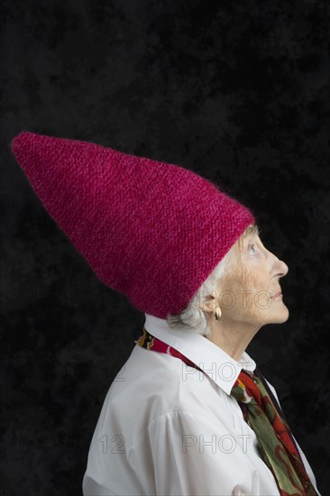 Close up of older woman wearing dunce cap