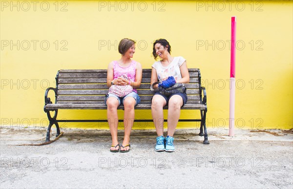 Caucasian women talking on bench