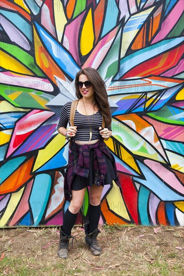 Caucasian woman smiling near multicolor mural