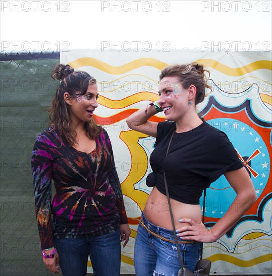 Women talking near multicolor mural