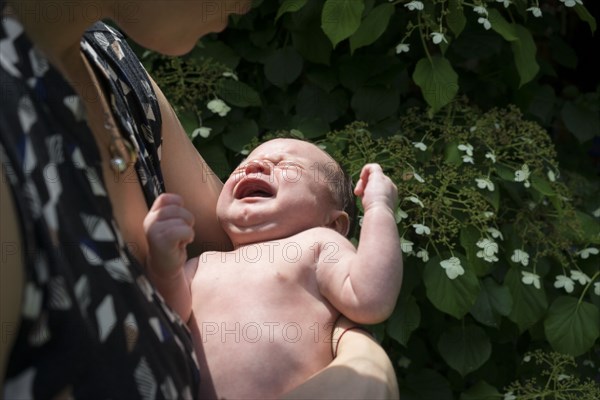 Mother holding crying baby in arms