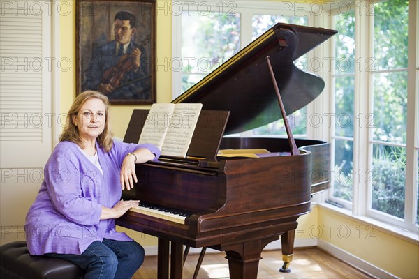 Caucasian musician leaning on piano