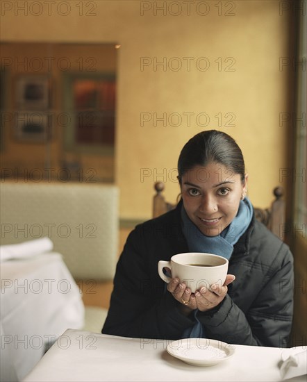 Indian woman drinking coffee in cafe