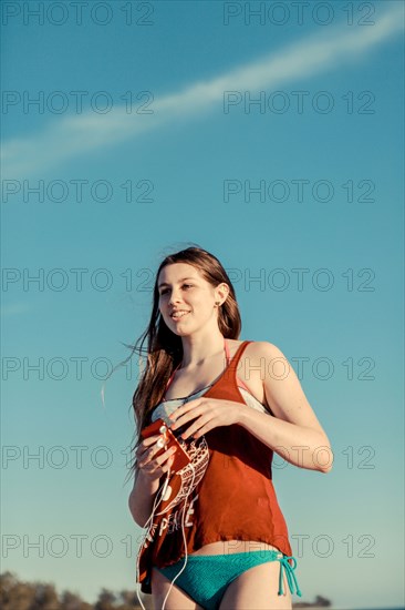 Caucasian woman wearing bikini under blue sky