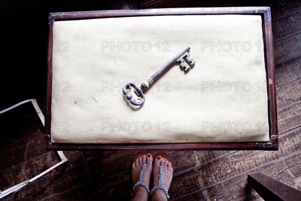 Woman standing near skeleton key on table