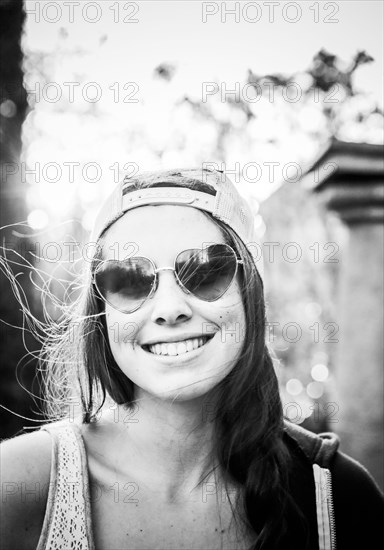 Caucasian teenage girl wearing heart-shaped sunglasses